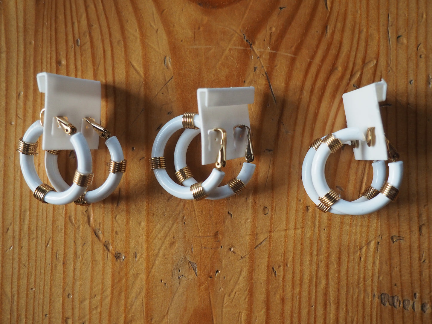 Valkoiset rengas klipsikorvakorut kultaisilla yksityiskohdilla