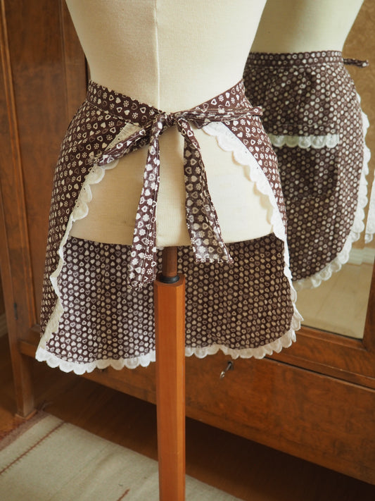 Ruskea kuviollinen essu pitsireunuksella