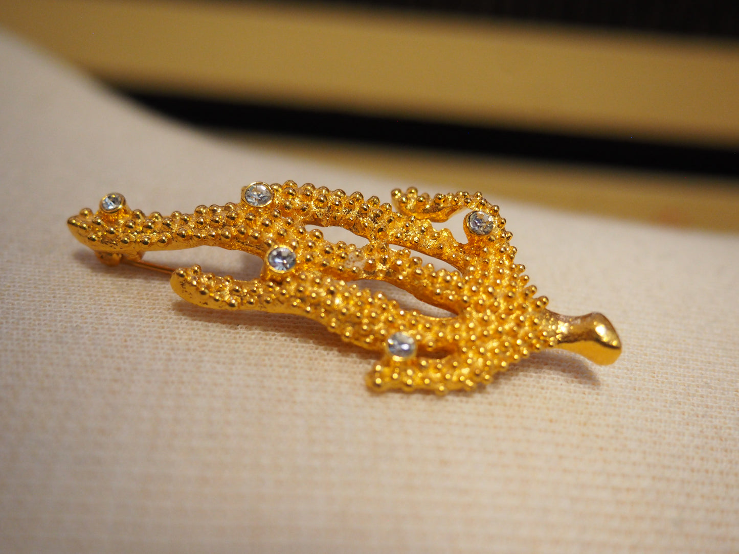 Kullansävyinen koralli rintaneula