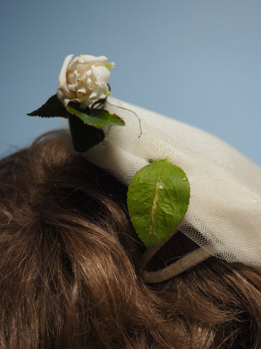 Valkoinen pillerihatuke koristekukalla