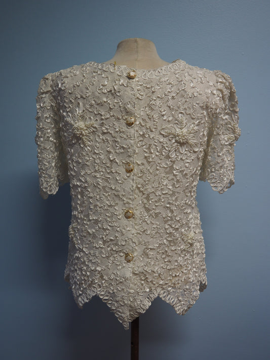 Valkoinen pitsikuvioinen ja helmikoristeinen pusero