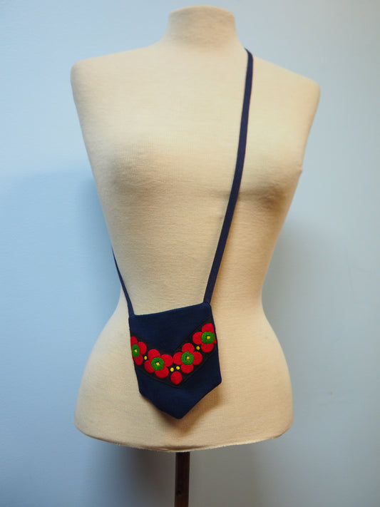 Tummansininen pitkä neulehame koristevyöllä sekä pussukka samaa sarjaa