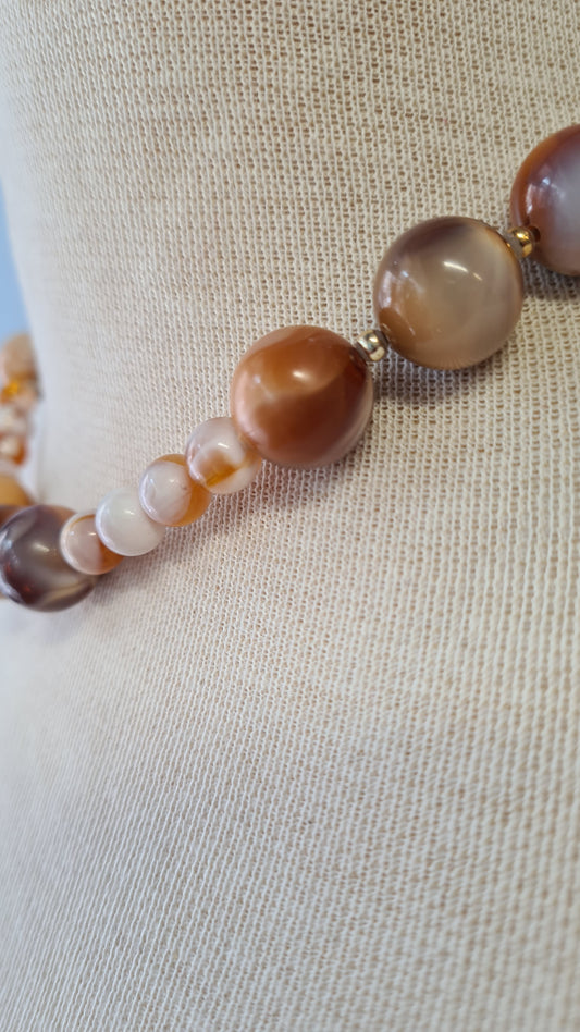 Vaaleanruskeat kuviolliset muovihelmet kaulakoru