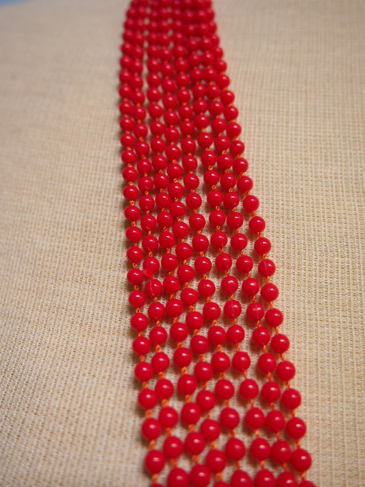 Punaiset monikerroksiset muovihelmet kaulakoru