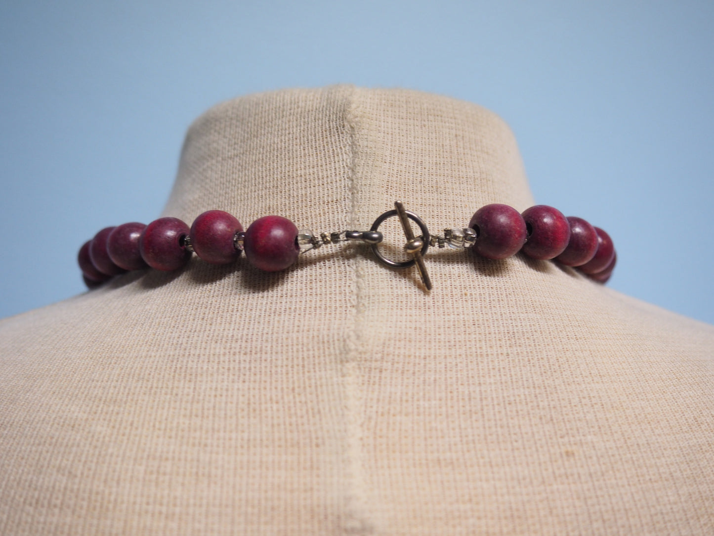 Tummanpunertavat puuhelmet kaulakoru