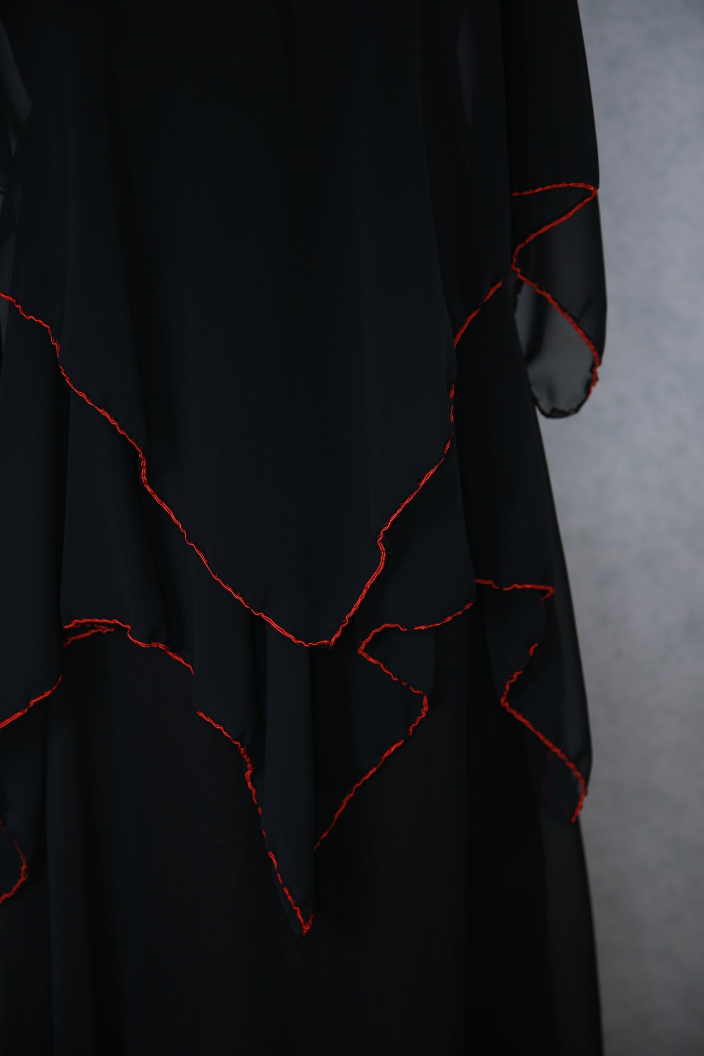 Musta pitkä mekko punaisilla yksityiskohdilla