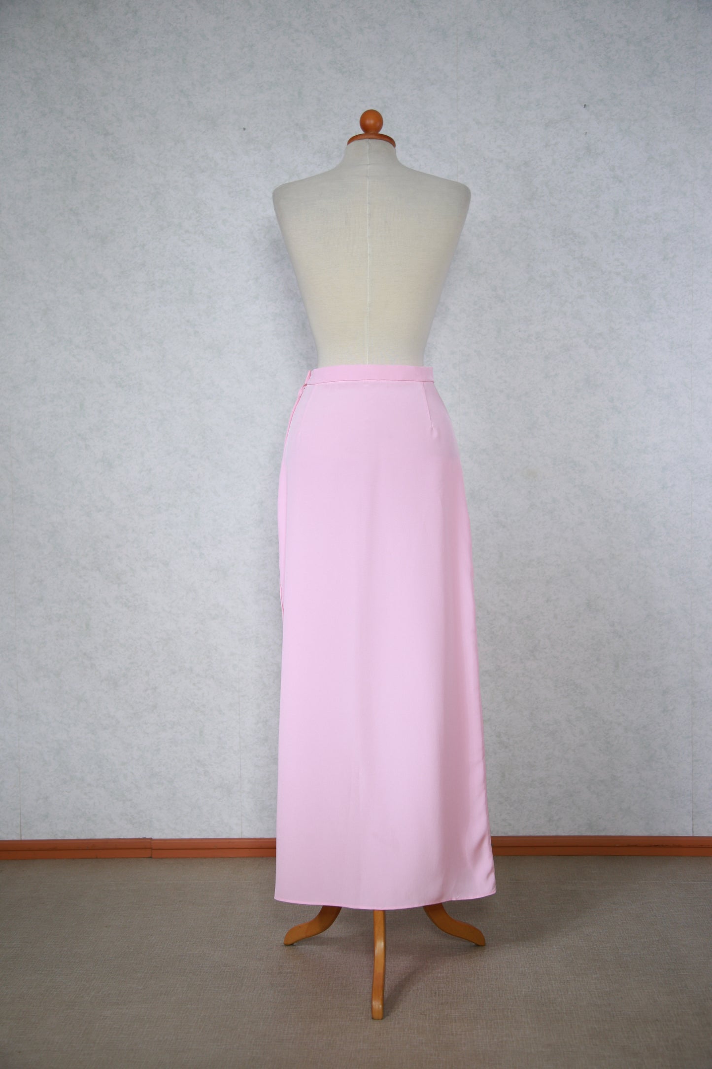 Vaaleanpunainen pitkä hame helmikoristeisilla napeilla