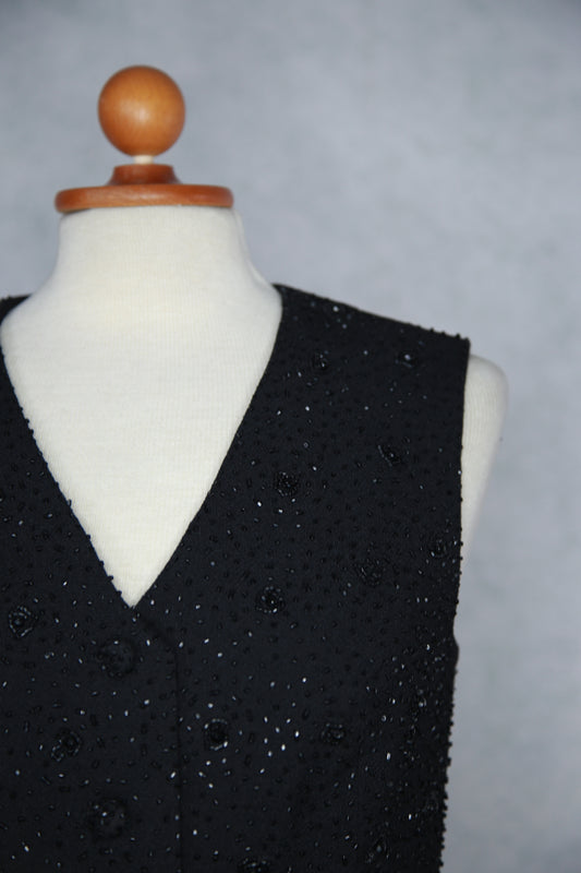 Musta kimalteleva liivitoppi helmikoristeilla