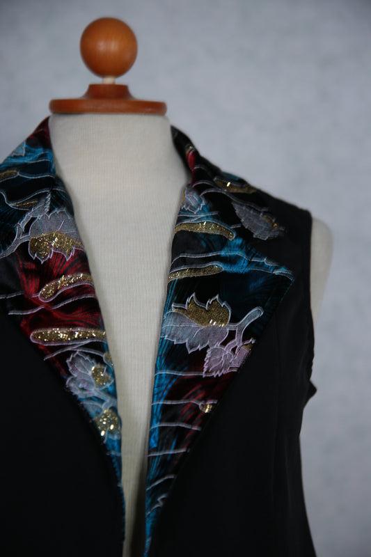 Musta liivi kimaltelevalla kauluksella