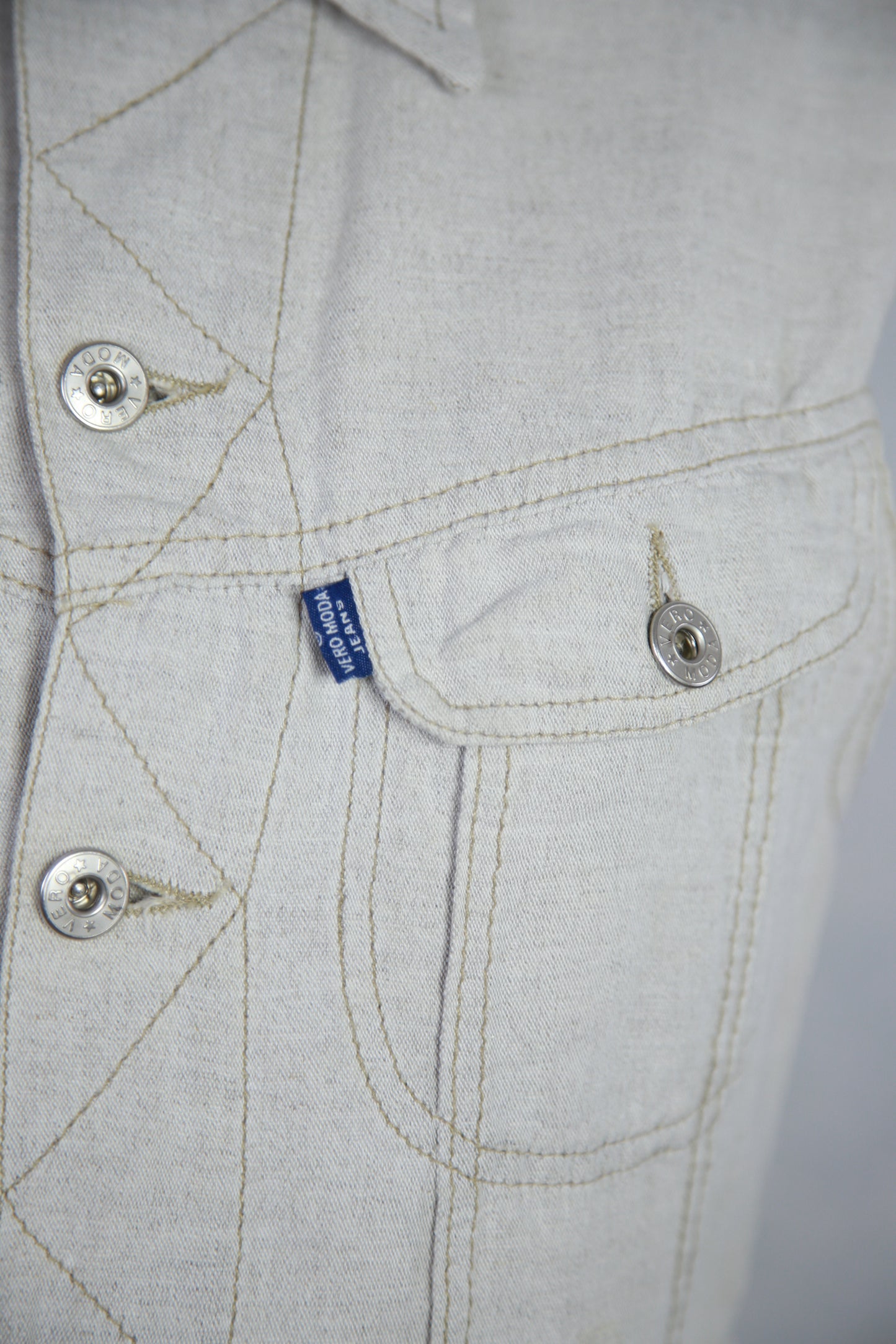 Vaalea liivitoppi taskuilla