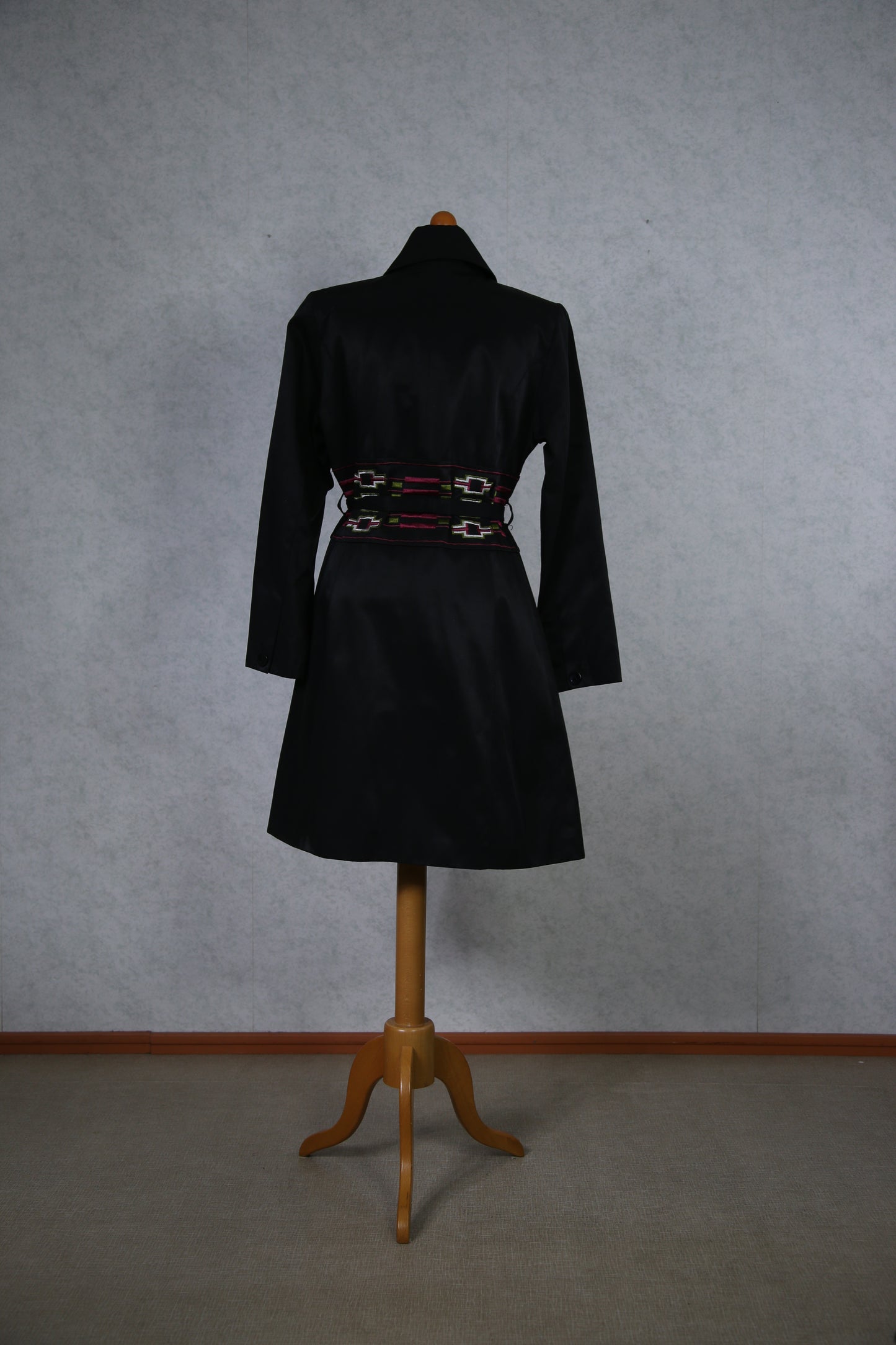 Musta takki koristeellisella vyötäröllä