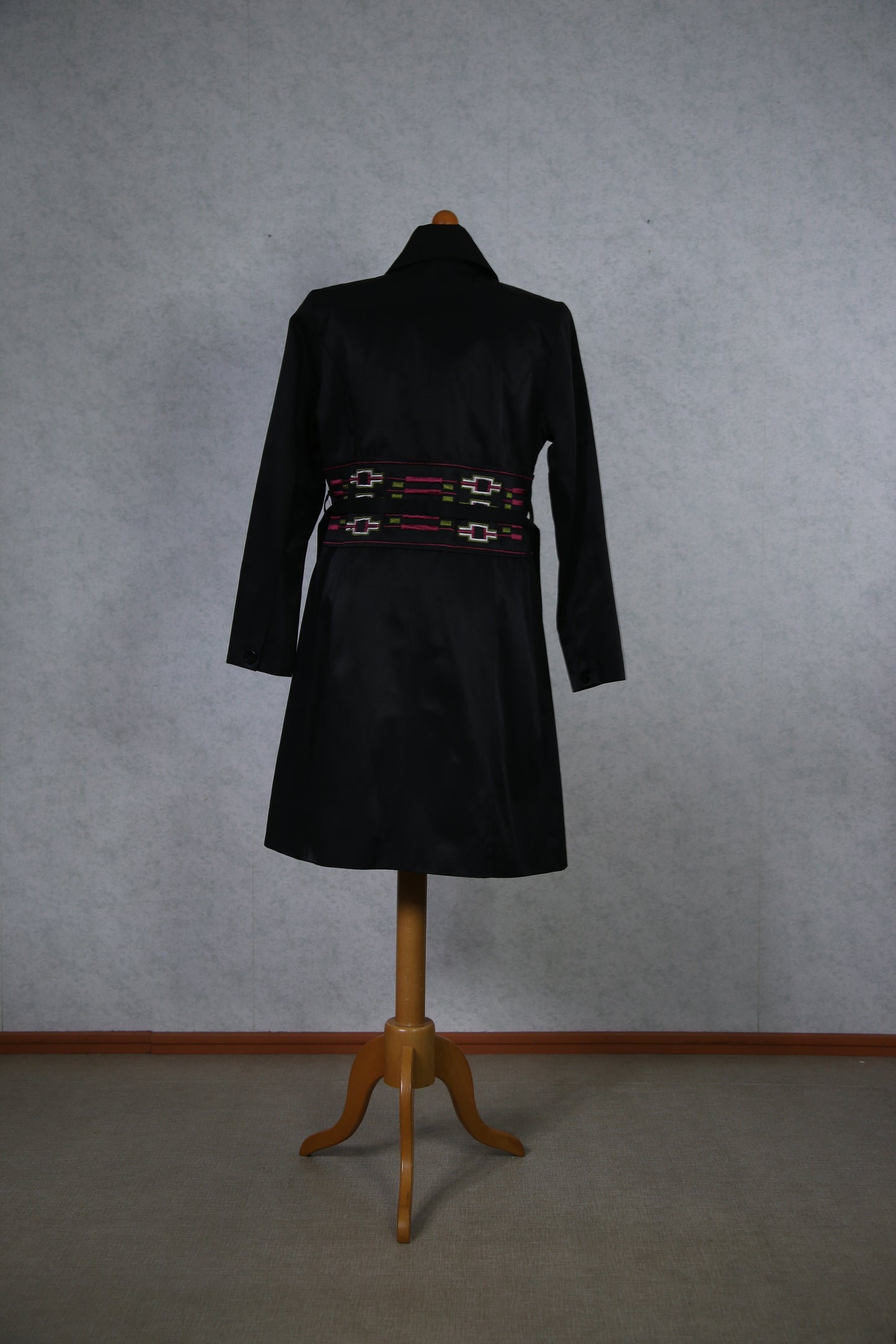 Musta takki koristeellisella vyötäröllä