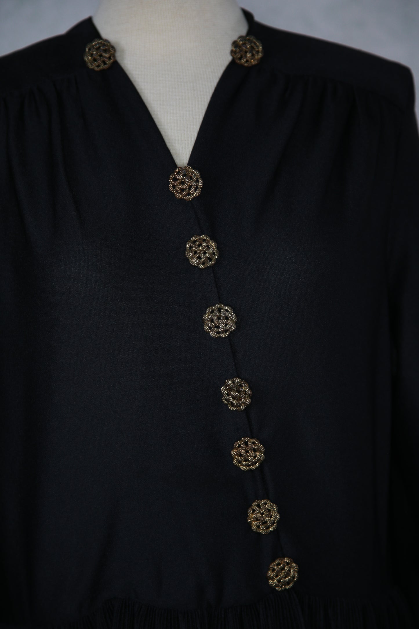 Musta mekko koristeellisilla napeilla